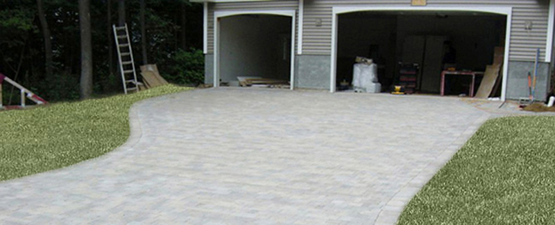 A beautiful long paver driveway leading up to the garage.